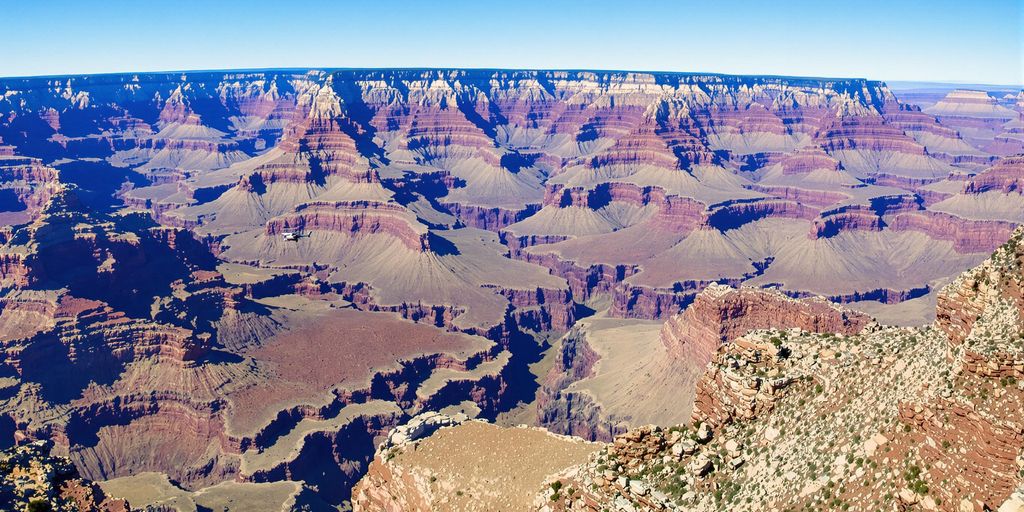 Helicopter flying over the Grand Canyon's stunning landscape.