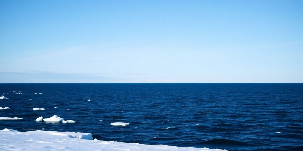 Snowy Alaska coastline, distant Russian shore haze.